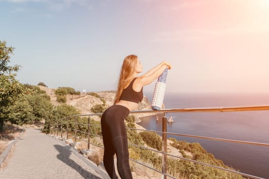 Fitness woman sea. Outdoor workout on yoga mat in park near to ocean beach. Female fitness pilates yoga routine concept. Healthy lifestyle. Happy fit woman exercising with rubber band in park.