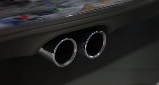Closeup of metal exhaust pipe of sports car. Car tuning concept