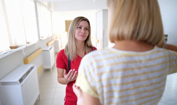 Young female doctor communicating with patient in clinic. Medical consultations concept