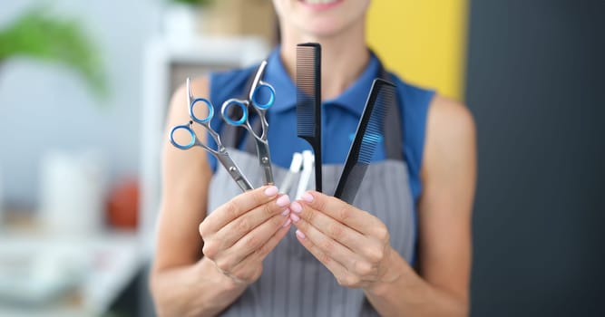 Woman hairdresser holding combs and scissors for hair cutting closeup. Educational training courses for hairdressers concept