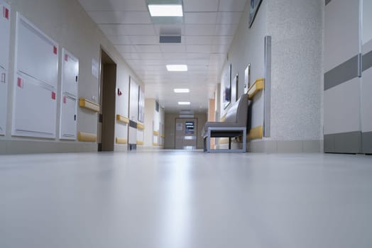 Modern spacious hospital corridor with comfortable couches for patients. Construction of medical institutions concept
