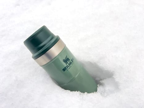 Antalya, Turkey - January 31, 2024: Stanley Action Trigger thermos mug standing in the snow in winter