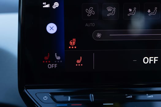 Switching ON heated seats of car by pressing the buttons. Heated seat dashboard in a car. Steering wheel heating button in the car. Electric car control panel with steering wheel and seat heating.