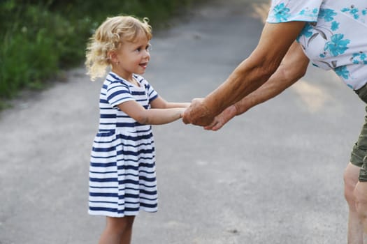 Child with grandmother holding hand. Selective focus. Nature.