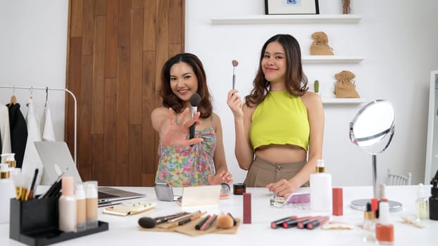 Two influencer partner shoot live streaming vlog video review makeup social media or blog. Happy young girl with vivancy cosmetics studio lighting for marketing recording session broadcasting online.