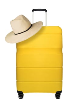 Travel yellow suitcase with straw hat isolated on white background. Plastic travel suitcase with hanging hat. Travel vacation concept