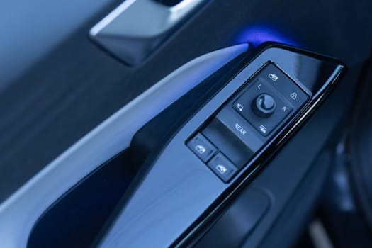 Window control buttons in modern luxury electric car. Car leather interior details of door handle with windows controls and adjustments. Car window controls. Door handle with power window control.