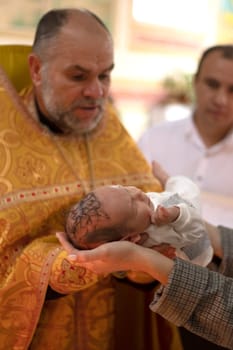 Ukraine, Khmelnitsky 02.10.2022. Infant baptism. Water is poured on the head of an infant. Christening the baby at the Orthodox church. Christian rite. orthodox rite. Christian baptism of a child
