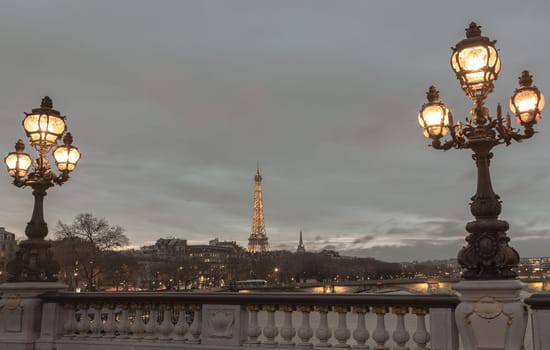 France, Paris - Jan 4, 2024 - Nice scenery of Eiffel Tower and Seine River in Paris. View from Pont Alexandre III Bridge at sunset. Destinations in Europe. Space for text, Selective focus.