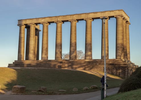 Edinburgh, Scotland - Jan 18, 2024 - A view of the National Monument of Scotland with a bright blue sky in the background situated on Calton Hill at Edinburgh city. Scotland, Space for text, Selective focus.