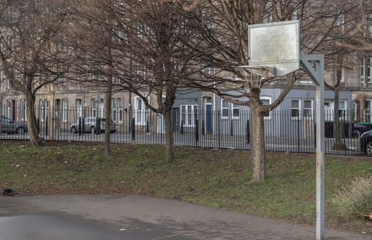 Edinburgh, Scotland, Jan 19, 2024 - Basketball backboard with the hoop metal ring in outdoor basketball courts at the city downtown. Space for text, Selective focus.