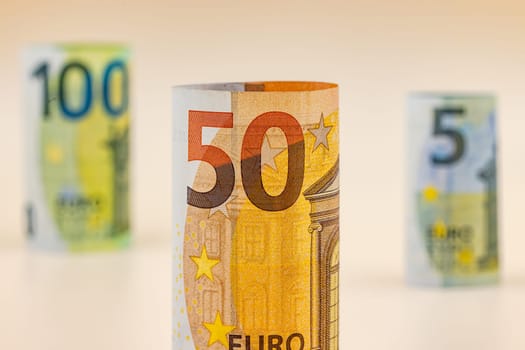 Euro banknotes worth 5, 50 and 100 euros as roll cut-outs in the studio