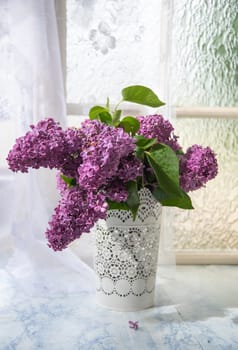 bouquet of purple lilacs in white openwork bucket on old shabby window sill with tulle curtain, romantic mood and spring freshness,comfort in the home,decoration of everyday life, High quality photo