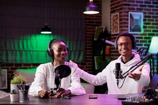 Team of content creators hosting online show in home studio, filming vlog, producing social media content. Vloggers recording episode for streaming service channel, entertaining audiences