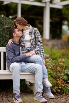 lovely young couple kissing outdoors in autumn. Loving couple walking in nature. Autumn mood. Happy man and woman hugging and kissing in autumn. Love. Fashionable couple outdoors. Fashion, people and lifestyle. Stylish couple in autumn outfit.