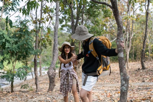 Happy LGBT Lesbian couple Travelers Hiking with Backpacks in forest Trail. LGBT Lesbian Couple Hikers with backpacks walks in mountains in vacation.