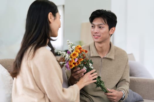 Young couple Hug and giving flower on Valentine's Day. Romantic day together. Valentine's Day concept.