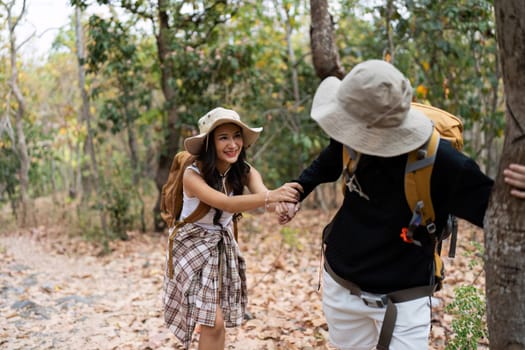 Happy LGBT Lesbian couple Travelers Hiking with Backpacks in forest Trail. LGBT Lesbian Couple Hikers with backpacks walks in mountains in vacation.