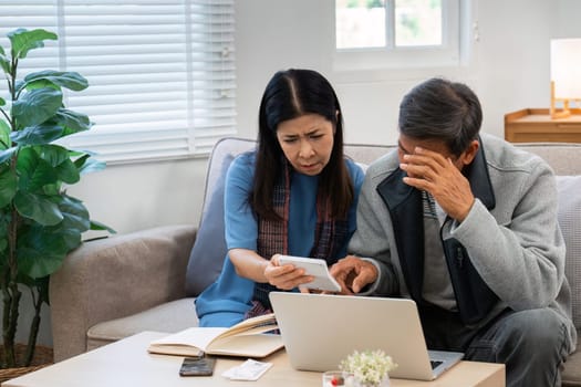 Stressed senior couple calculate expenses or planning budget together at home.