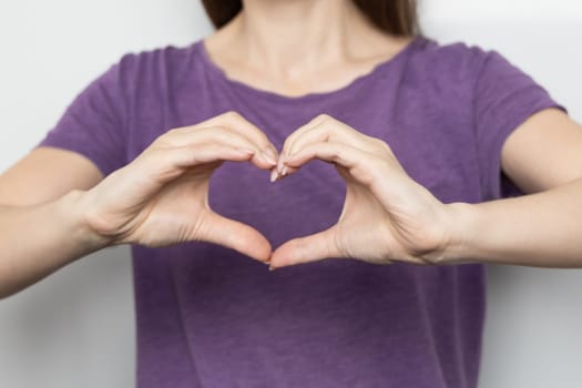 Inspire inclusion. Zoomers symbolize love. Faceless woman finger heart dressed purple t-shirt. Hand showing heart. International Women's Day 2024 banner, InspireInclusion