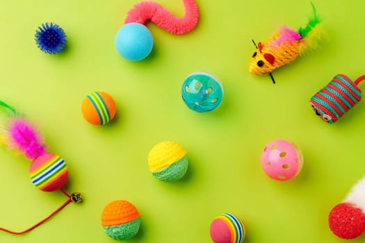 Colorful pet toys balls on green background close up