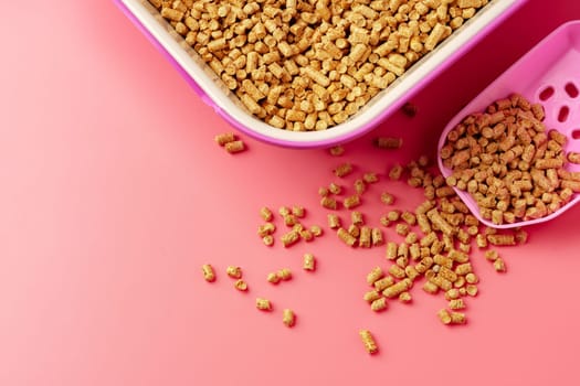 Pet litter box with bio filler on pink background close up