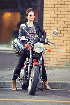 Motorcycle, leather and woman on street with sunglasses for travel, transport or road trip as rebel. Fashion, city and model with attitude on classic or vintage bike for transportation or journey.