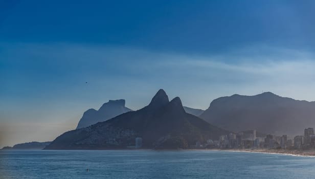 Rio de Janeiro's iconic mountains stand out against a twilight sky above the ocean.