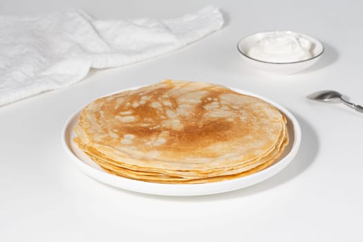 Thin pancakes in a plate. Concept of delicious breakfast or Maslenitsa.