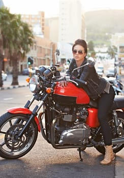 Motorcycle, leather and woman in city with sunglasses for travel, transport or road trip as rebel. Fashion, street and model with attitude on classic or vintage bike for transportation or journey.
