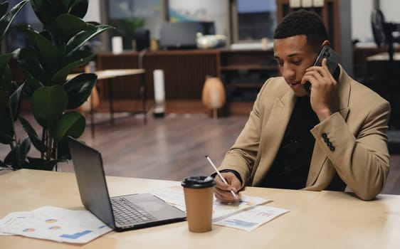 Man sitting by table working on laptop computer.