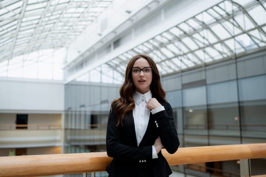 Mature business woman looking at the camera in a workplace meeting area.