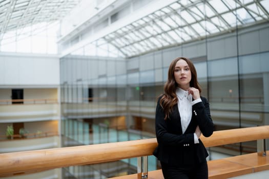 Mature business woman looking at the camera in a workplace meeting area.