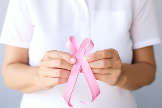 Close up of hands and pink cancer awareness ribbon. Generative AI.