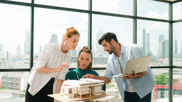 Smart architect team discussion about house design while handsome male worker present idea by using laptop. Group of professional engineer sharing, brainstorming design. Business design. Tracery