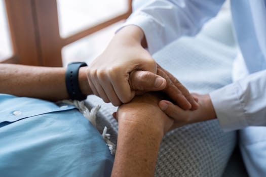 Doctors or nurses hold hands of elderly patients to support and soothe.