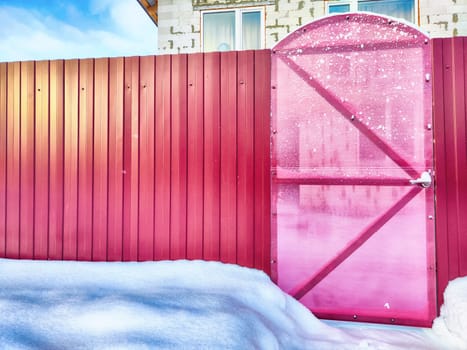 New gate, entrance to a private territory on a winter day and snow. Metallic texture and background. Fence