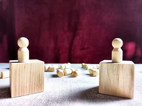 Wooden toys stand opposite and lot of lying figures. Concept of dispute between leaders of two groups. Government and deaths of citizens and soldiers. War in Russia, Ukraine, Israel, Palestine