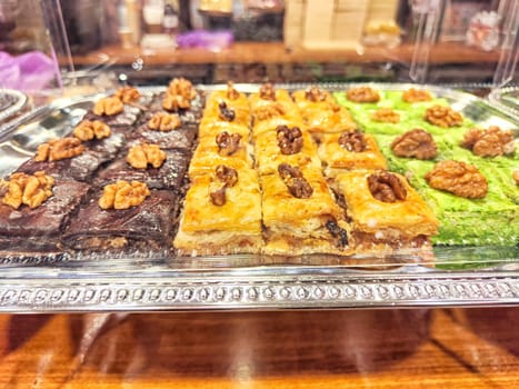 Various types or many colorful assortment of Turkish sweets for sale in shop food festival. Baklava and pastries are sold on trays on the counter. Ramadan, travel