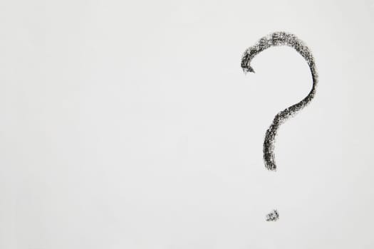 Handwritten question mark in black chalk on a white background. Business concept, doubts, insecurities