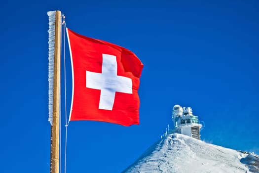 Swiss flag on Jungfraujoch peak view, Berner Oberland region of Switzerland