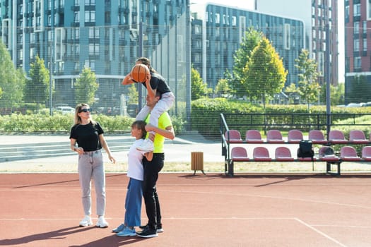 the family plays basketball on the court. High quality photo