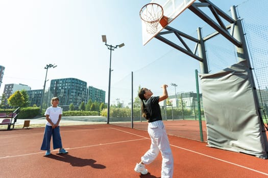 Children and sports. Teenage girl playing basketball on the playground. High quality photo