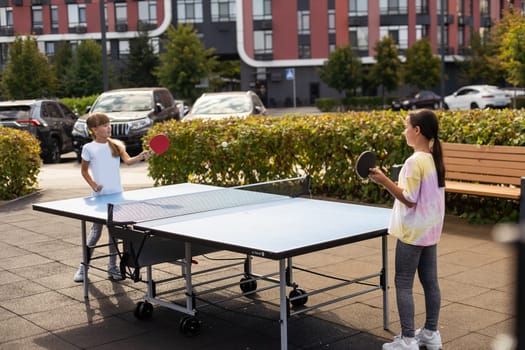 Little children playing ping pong in park. High quality photo