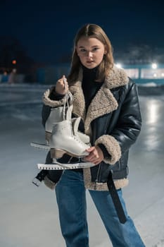 Beautiful young woman at the ice skating park. Winter activities concept