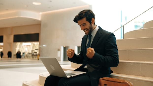 Executive manager celebrate successful project or getting promotion, getting new job. Professional business man express feeling joy and happy while using laptop checking increasing sales. Exultant.