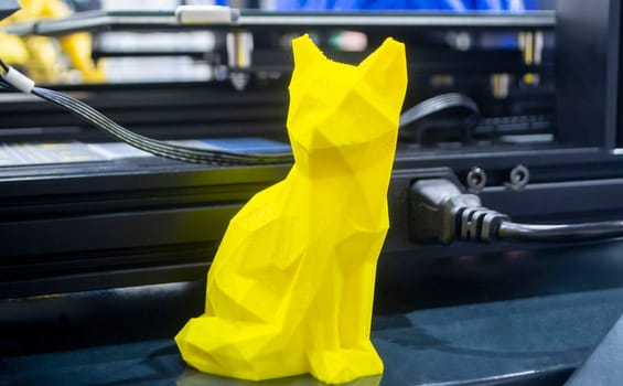 Art object model of cat printed on 3D printer. Toy cat created by 3D printing from molten plastic. Example of creating prototype by 3D printer. Concept 3D printing. 3D printing innovation technology