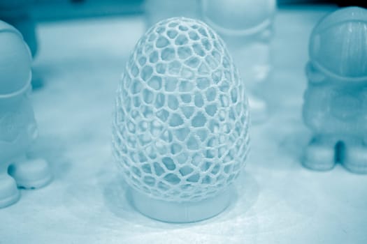 Art object model of egg printed on 3D printer. Egg toy created by 3D printing from molten plastic. Example of creating prototype by 3D printer. Concept 3D printing. 3D printing innovation technology