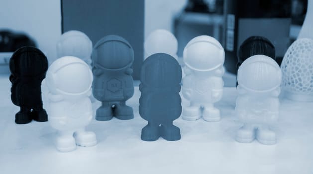 Art object model of astronaut printed on 3D printer. Toy created by 3D printing from molten plastic. Example of creating prototype by 3D printer. Concept 3D printing. 3D printing innovation technology