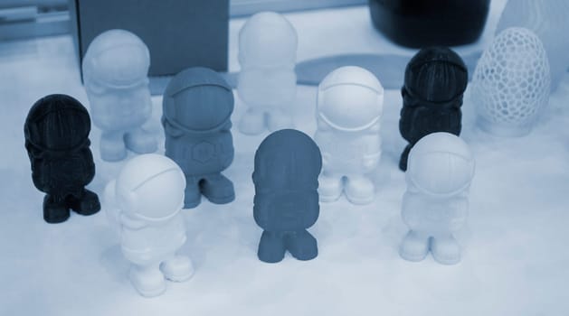Art object model of astronaut printed on 3D printer. Toy created by 3D printing from molten plastic. Example of creating prototype by 3D printer. Concept 3D printing. 3D printing innovation technology